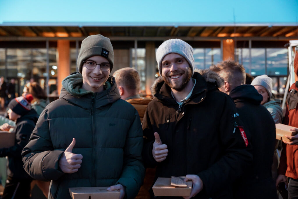 Oskar (17) and Edwin (26) get some food after the evening meeting